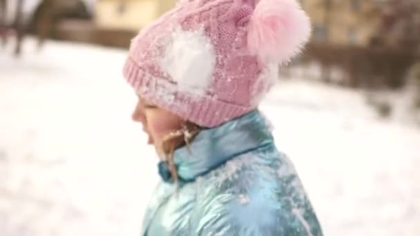 公園で雪の戦い後雪だるまの痕跡と悲しい少女の肖像画 冬のゲームの子供の冬のレジャー — ストック動画
