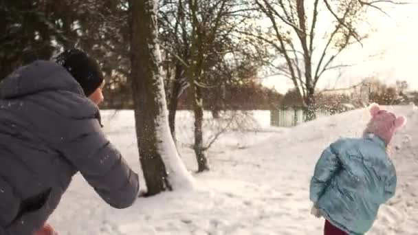 Neşeli kar mücadele. Baba ve kızı birbirleriyle kartopu ile düşer. Mutlu aile tatil, kış hafta sonları, kış parkta bir yürüyüş — Stok video