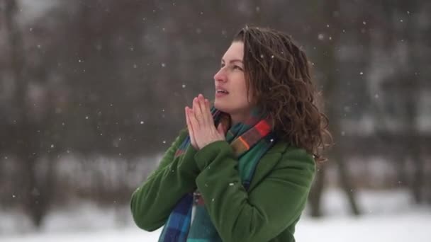 Portrait of beautiful curly girl in winter time. The woman is cold and warm hands breathing — Stock Video