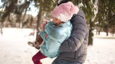 Bir kız babası ile kartopu oynuyor, yüzünü kar ile smear neşeyle gülüyorlar. Mutlu kış aile tatilleri