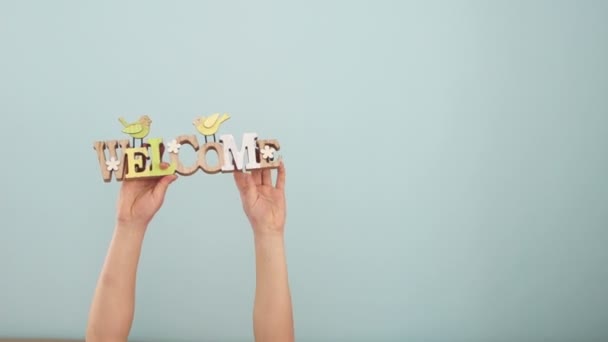 As mãos das crianças em um fundo de hortelã seguram sinais sobre o tema da primavera e da Páscoa. Cores pastel suaves, decoração de primavera alternativa, dia das mães, conforto em casa — Vídeo de Stock