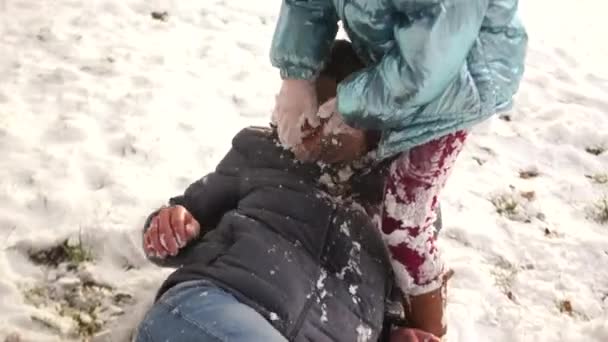 Filha adolescente e pai maduro jogar bolas de neve. A menina desesperadamente mancha seu pai com neve, o homem levanta as mãos e desiste — Vídeo de Stock