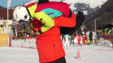 Bir kayak merkezinde mutlu çift tatilde. Bir erkek ve bir kadın diye bağırıp karlı dağ zirveleri arka plan üzerinde kucaklamak. Aktif yaşam tarzı, spor malzemeleri