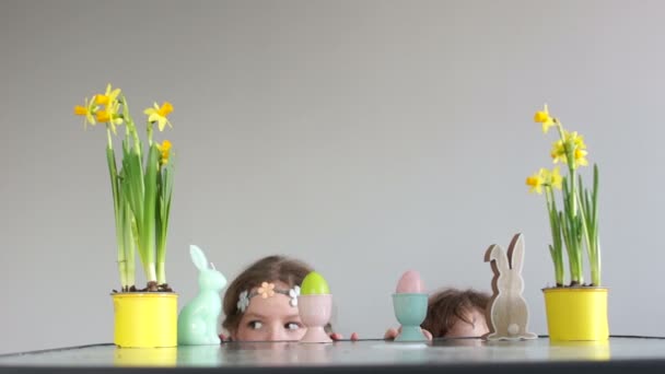 Kız ve erkek kardeşim, tablo Easter dekor ile gelen öğrenciler dikkat edin. Mutlu Paskalya Paskalya yumurtaları için arıyorsunuz — Stok video