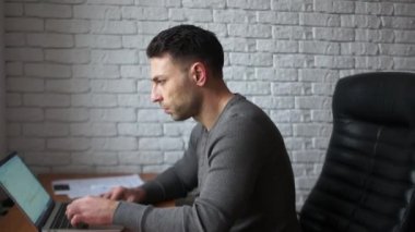 Laptop ile çalışan genç esmer programcı tasarımcı. İnsan odaklı ve konsantre, freelancing içinde zaman yönetimi