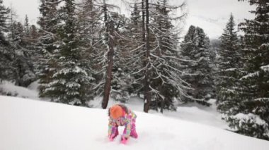 Kar köknar ağaçları zemin karşı parkta oynarken pembe Kayak elbiseli güzel dört yaşındaki kız. Kış tatili, oyuncağı, mutlu bir aile bir Kayak Merkezi, kış