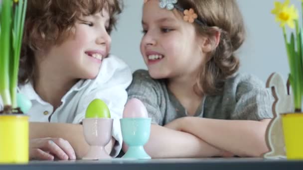 Påsktraditioner. Pojke och flicka slå kyckling ägg mot varandra. Påsk dekoration — Stockvideo