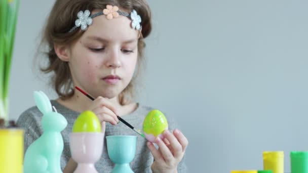 Petite fille mignonne peignant oeufs de Pâques whith brosse dans la couleur de la chaux. Concept de Pâques — Video