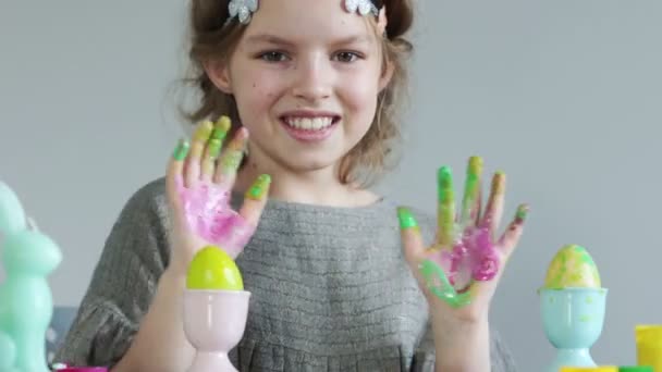 Пасхальный портрет счастливой школьницы. Руки девочек запятнаны краской. Детское творчество, раскраска пасхальных яиц — стоковое видео