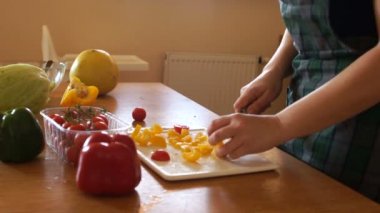 Anne mutfakta sebze salatası hazırlar, küçük kızı çalıştıran ve bir domates kapmak. Mutlu aile yemek