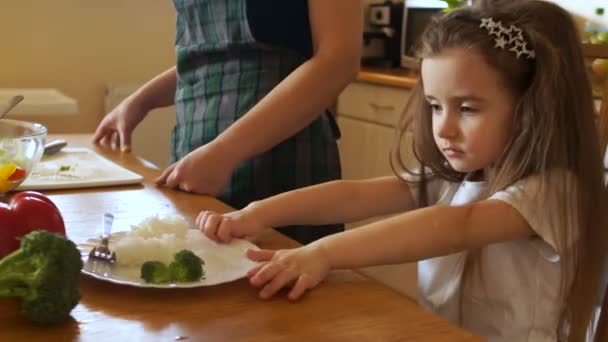 Long-haired Dziewczyna w kuchni popycha jego talerz z jedzeniem. Prawidłowe odżywianie dla przedszkolaków — Wideo stockowe