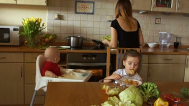 Bakıcı mutfakta - iki çocuk besleme ile öğle yemeği ve akşam yemeği hazırlanıyor. Ev personeli personel ajansı