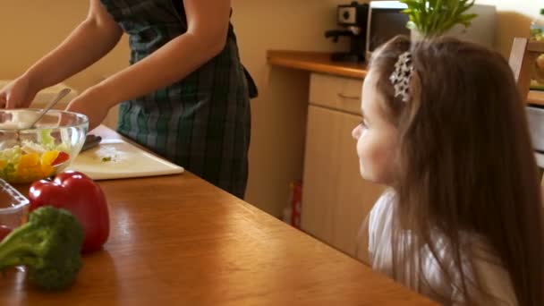 Nyttig mat hemma. Lycklig familj i köket. Mor och barn dotter förbereder grönsakerna — Stockvideo