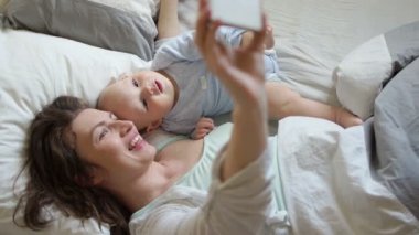 Anne ve bebek alarak selfie yatakta. Anneler günü, anne sevgi, mutluluk annelik