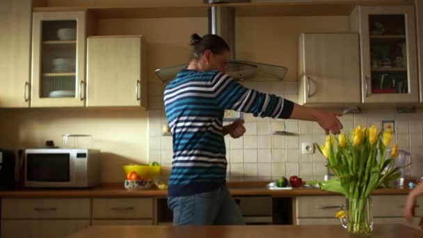 Husband and wife, a loving couple fooling around in the kitchen. Depict pantomime, all fools day — Stock Video