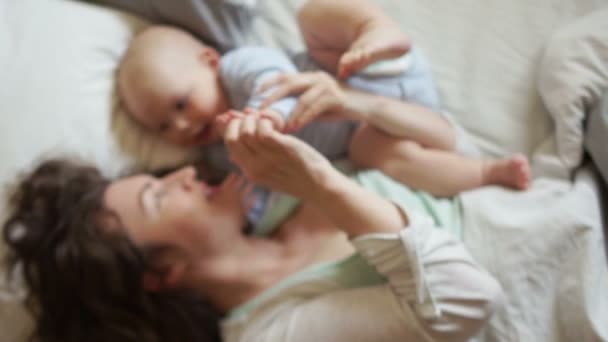 Happy baby en moeder in bed kijken elkaar. Goede familie ochtend, Moederdag — Stockvideo