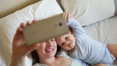 Öz anne ve bebek yatakta. Mutlu aile sabah. Annelik ve ebeveynlik kavramı
