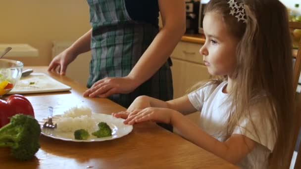 La chica empuja decisivamente un plato de comida. Mira a la madre y sacude la cabeza, el niño se niega a comer — Vídeos de Stock