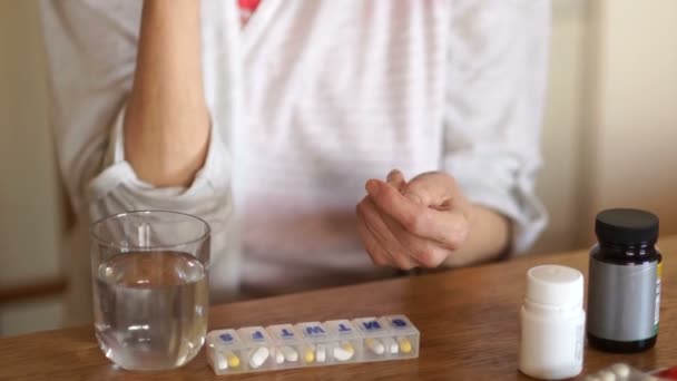 Γκρο πλαν βραχίονα του ένα άτομο που πάσχει από αρθρίτιδα. Ώριμη γυναίκα παίρνει χάπια και βιταμίνες με νερό. Έννοια της ιατρικής και φαρμακευτικής — Αρχείο Βίντεο