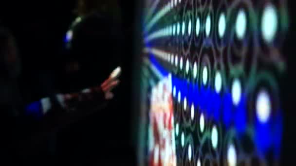 Garçon touche une main à un énorme mur interactif. Grand écran lumineux avec des motifs lumineux 