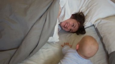 Anneler günü. Anne ve bebek saklambaç oynayalım sabahları yatakta. Annesi bir battaniye ile onun baş ile kaplıdır, çocuk ona tarar ve açılır