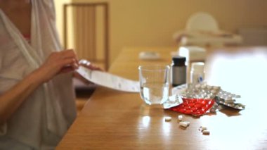 Bir kadının el portresi kapatın. Tarifi ve alır bakar hap onları sıkılmış bir bardak su ile