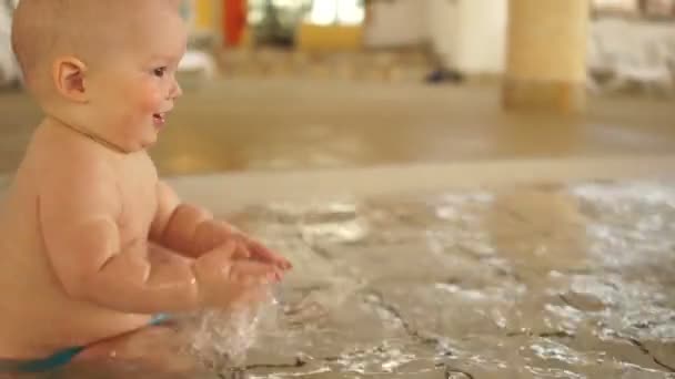 Bebé salpicando en la piscina caliente para los niños. El fortalecimiento de la inmunidad, el desarrollo de los niños — Vídeo de stock