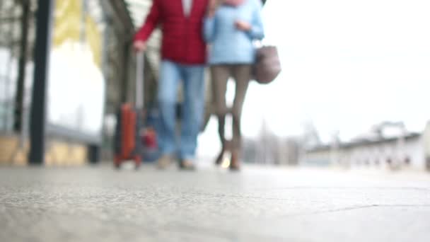 Onherkenbaar man en vrouw lopen langs het platform met een koffer. Casual stijl, concept van de reizen en vervoer — Stockvideo