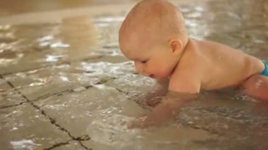 Bebek ve küçük olanlar için sığ bir sıcak havuzda su dökülüyor. Güçlendirilmesi, dokunulmazlık bir aquapark içinde kalan