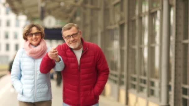Portrét krásné starší pár na procházku. Manžel a manželka chodí držel ruku po celém městě a smích. Důchodci na procházce — Stock video