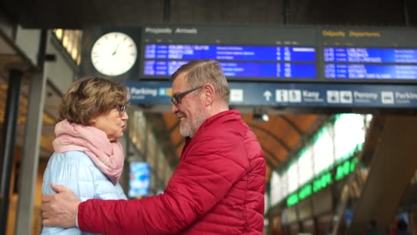 Sensuele afscheid van een bejaarde echtpaar bij het station. De dag van Valentijnskaarten, reizen concept — Stockvideo