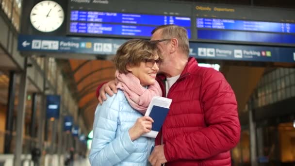 Felice coppia matura ridendo e abbracciandosi sul binario della stazione ferroviaria. San Valentino, viaggio in famiglia — Video Stock