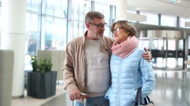Emekliler dünyayı dolaşıyor, yaşlılık mutlu. Olgun adam ve kadın havaalanında bir bavul ile konuşurken ve gülüyor