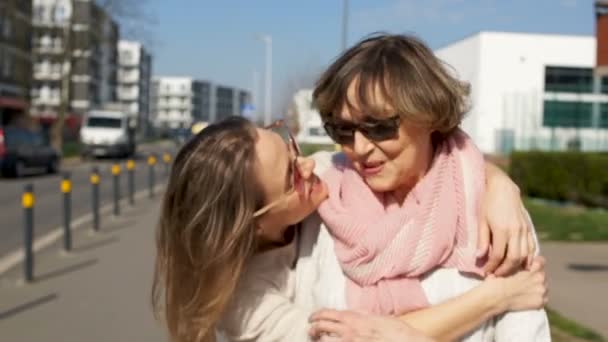 Stadtporträt von Mutter und Tochter. zwei Frauen umarmen und lachen fröhlich. Sommerporträt — Stockvideo