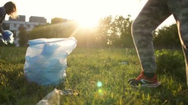 Gün batımında, gönüllüler büyük bir plastik torba içinde bir şehir parkı çöp toplamak. Adam paketi alır ve gider.