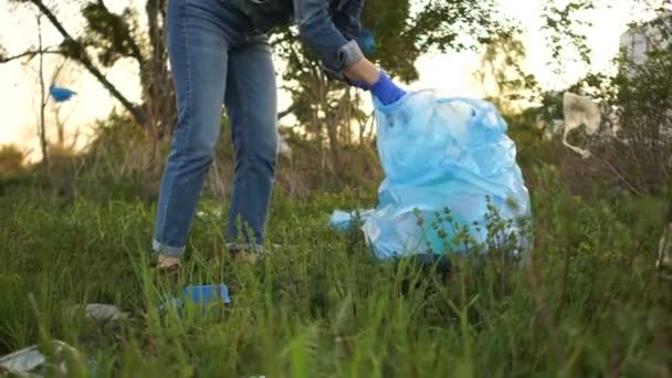 Una voluntaria recoge basura en un parque suburbano. Detener la contaminación plástica, plástica del planeta, concepto social — Vídeos de Stock