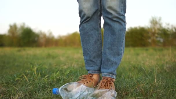 Ekoloji kavramı. Kadın bacak çim plastik bir şişe üzerinde gelir, yakın çekim, plastik durdurmak, ev çöp — Stok video