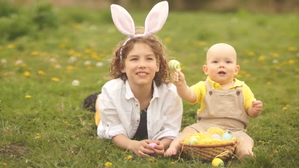 Leuke kinderen in de weide met een easter basket. Pasen concept, licht groen, gele kleuren — Stockvideo