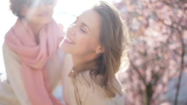 Весняний портрет двох жінок на фоні квітучої магнолії. День матері, Міжнародний жіночий день — стокове відео