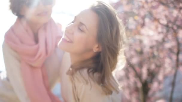 Ritratto di primavera di due donne su uno sfondo di una magnolia fiorente. Festa della mamma, Giornata internazionale della donna — Video Stock