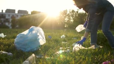 Erkek ve kadın gönüllüler bir bahar parkında çöp kaldırmak ve büyük bir plastik torbaya koymak