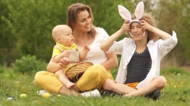 Annem ve iki oğlu çayırda. Paskalya pikniği, tavşan kostümü. Mutlu paskalya ailesi