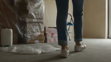 Bir kız ayakları nın arka görünümü dairesinde tamir etmeye başlayan, bir merdiven üzerinde duruyor, duvar boyamaya başlar