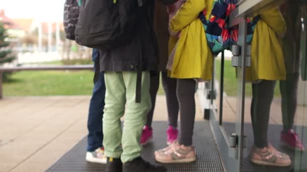 Vista de abajo. Adolescentes irreconocibles rodearon a la chica y les arrancaron las gafas, dorando su libro. La colegiala se sienta y llora. Bulling en el concepto escolar — Vídeos de Stock