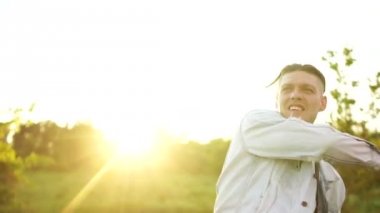 Kot ceketli genç bir adam Amerikan bayrağını sallayıp bağırıyor. Gün Batımı, Bağımsızlık Günü, 4 Temmuz