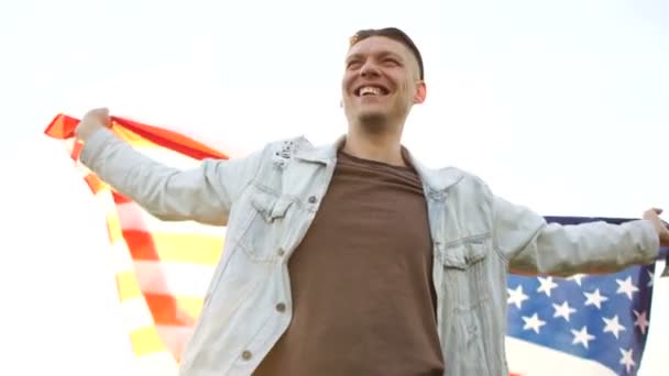 Щасливий хлопець святкує День незалежності 4 липня в парку на тлі літнього неба. Національне свято Сполучених Штатів Америки — стокове відео