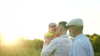 Babam bir yaşında bir bebek kusuyor. Babalar günü Mutlu aile hafta sonu. Büyükbaba, oğlu ve torunu bir yürüyüş için