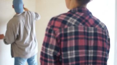 Onların yeni ev tadilatı ve boyama iç duvarları birlikte mutlu çift: yaşam tarzı, ev makyaj ve remodeling kavramı