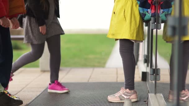 Vista della metà inferiore del corpo. I bambini circondarono una compagna di classe e la insultarono, lanciarono un libro e dei bicchieri. Bulling a scuola concetto — Video Stock