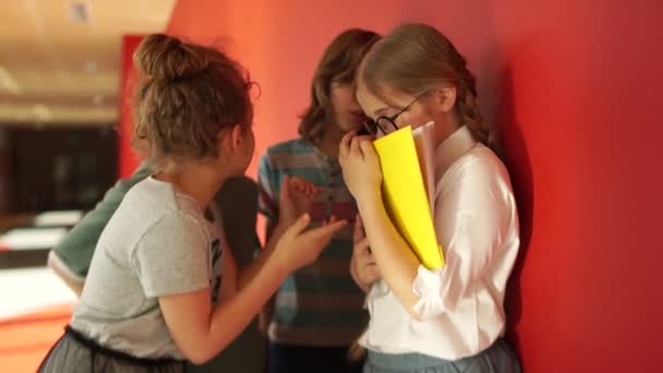 Дівчина хуліган ображає свого однокласника на честь учня. Дай їй окуляри і книжку. Фізичне насильство серед підлітків. Жертва втікає — стокове відео